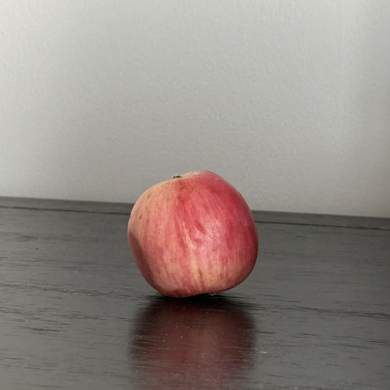 This is an apple in another perspective, its appearance is sphericity,I chose it because it's the closest thing to a sphere in my home and it's obvious at a glance that it's a sphere.